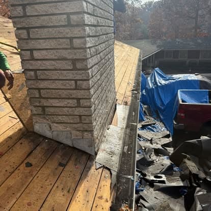 Rooftop chimney repair with tarps and construction materials visible on a residential home.